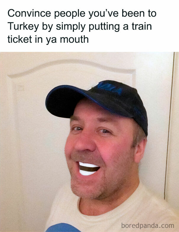 Man with a playful smile holds a train ticket in his mouth as part of a humorous Scottish joke.