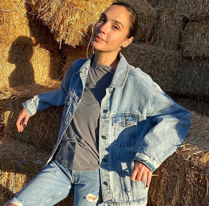 Person in a denim jacket and jeans sitting on hay bales; related to Disney and Snow White controversy. Person in a denim jacket and jeans sitting on hay bales; related to Disney and Snow White controversy.