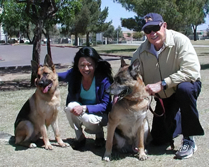 Gene Hackman and Betsy Arakawa smiling with two German Shepherds at a park. Gene Hackman and Betsy Arakawa smiling with two German Shepherds at a park.