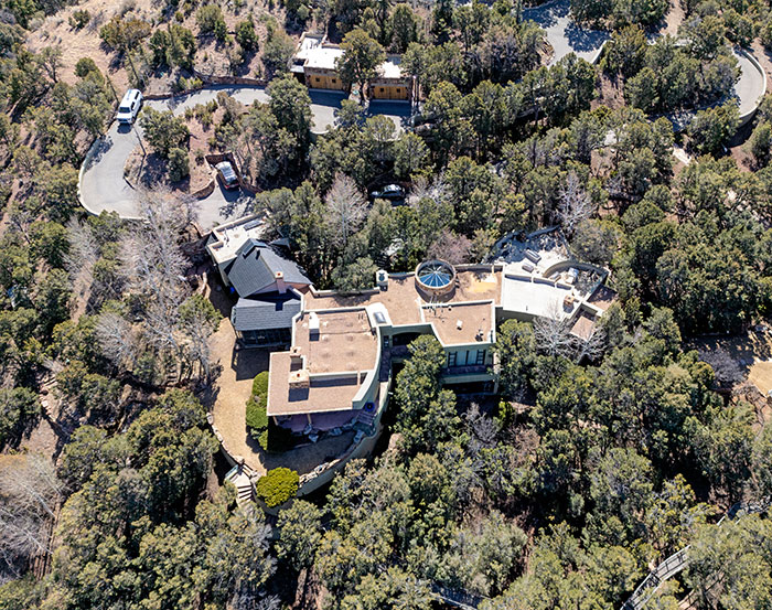 Aerial view of a large, secluded house surrounded by trees, related to the Gene Hackman mystery. Aerial view of a large, secluded house surrounded by trees, related to the Gene Hackman mystery.