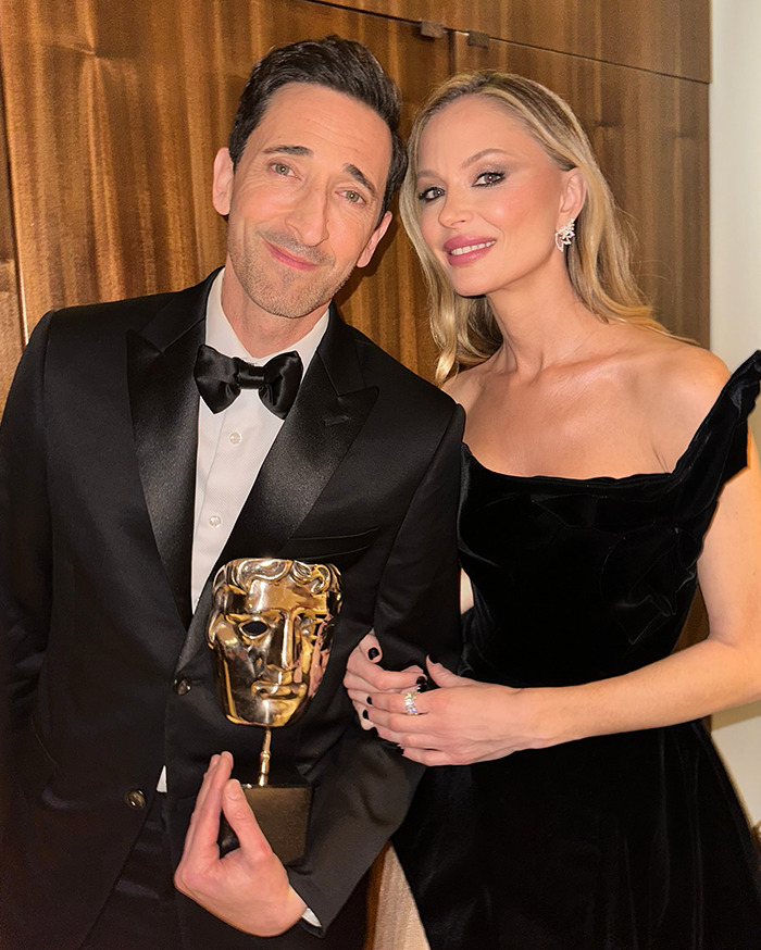 Adrien Brody holding award, smiling with Georgina Chapman wearing black formal attire. Adrien Brody holding award, smiling with Georgina Chapman wearing black formal attire.