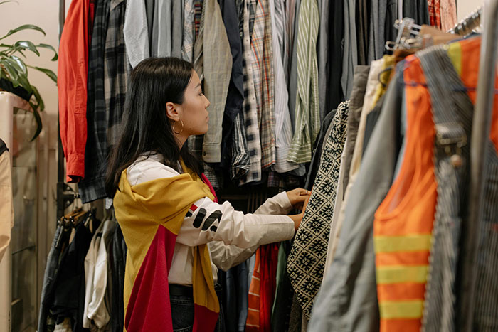 Teen girl choosing clothes in a store, wearing a colorful jacket, related to body-shaming issues. Teen girl choosing clothes in a store, wearing a colorful jacket, related to body-shaming issues.