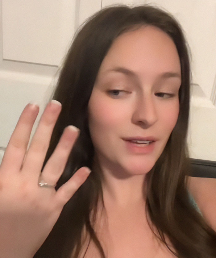 Woman showing engagement ring, proud of fiancé's proposal at another wedding, sparks fury online. Woman showing engagement ring, proud of fiancé's proposal at another wedding, sparks fury online.