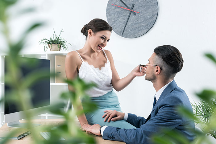 Two colleagues smiling in a modern office, symbolizing a close work relationship. Two colleagues smiling in a modern office, symbolizing a close work relationship.
