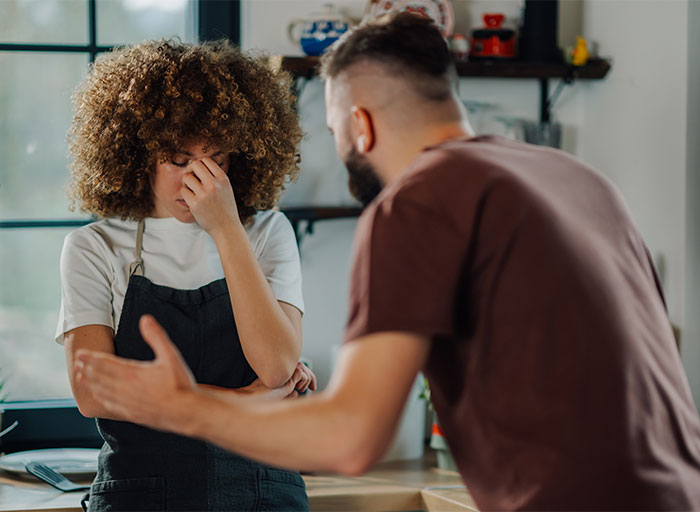 Man gestures while a woman looks stressed, highlighting wealth dynamics in relationships. Man gestures while a woman looks stressed, highlighting wealth dynamics in relationships.