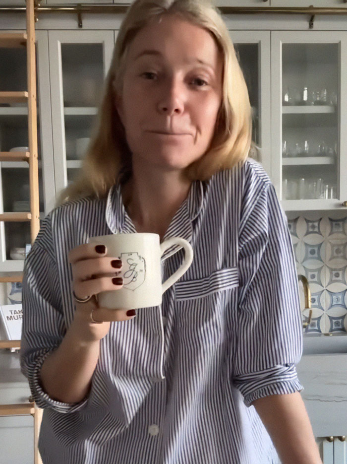 Gwyneth Paltrow in a kitchen holding a mug, wearing a striped shirt, addressing feud rumors. Gwyneth Paltrow in a kitchen holding a mug, wearing a striped shirt, addressing feud rumors.