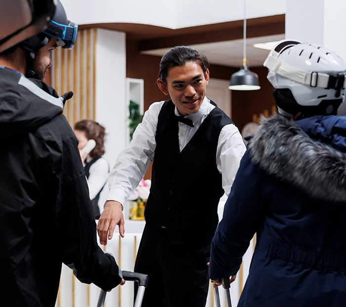 Uniformed waiter engaging with customers at a restaurant. Uniformed waiter engaging with customers at a restaurant.