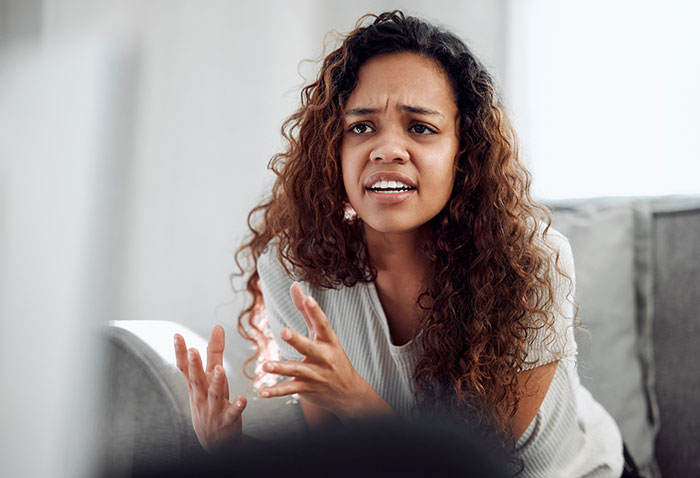 Woman with a concerned expression, discussing a risky prank by her husband. Woman with a concerned expression, discussing a risky prank by her husband.