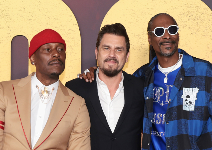 Three men posing together, Snoop Dogg wearing sunglasses and a blue jacket, representing aspects of Snoop Dogg's net worth. Three men posing together, Snoop Dogg wearing sunglasses and a blue jacket, representing aspects of Snoop Dogg's net worth.