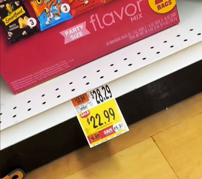 Grocery price in the US shows a party-size snack box labeled at $28.29, discounted to $22.99, highlighting cost concerns.