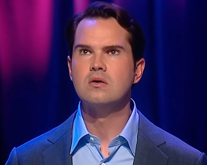 Man in blue shirt and blazer, looking upwards on stage, discussing cosmetic tweakments. Man in blue shirt and blazer, looking upwards on stage, discussing cosmetic tweakments.