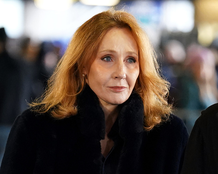 A person with red hair in a dark coat, appearing thoughtful against a blurred background, related to recent Harry Potter controversy. A person with red hair in a dark coat, appearing thoughtful against a blurred background, related to recent Harry Potter controversy.