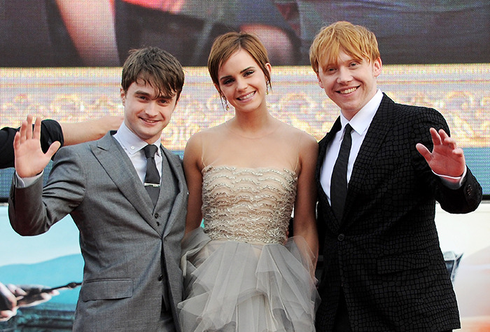 Harry Potter stars smiling and waving at a movie premiere event. Harry Potter stars smiling and waving at a movie premiere event.