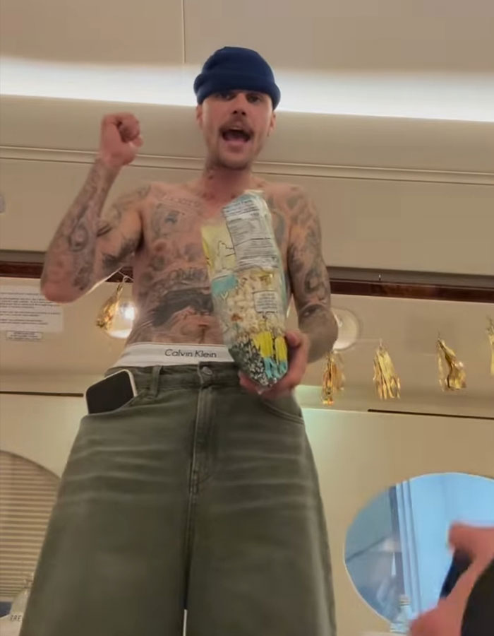 Shirtless man with tattoos, wearing a beanie, holds a colorful bag in a casual setting, addressing impostor syndrome concerns. Shirtless man with tattoos, wearing a beanie, holds a colorful bag in a casual setting, addressing impostor syndrome concerns.