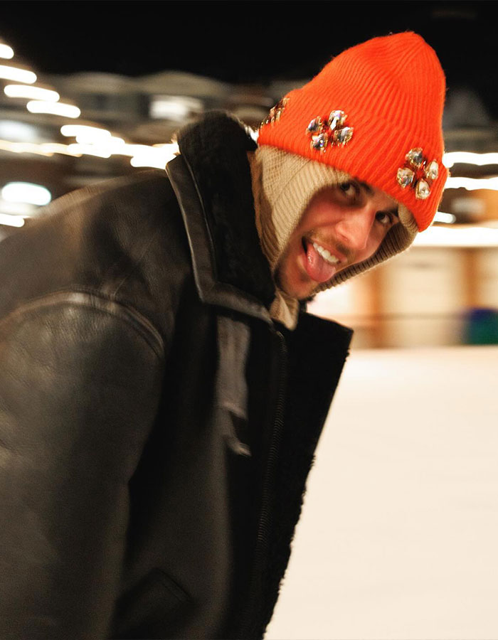 Person in a bright orange beanie and black jacket smiling, embodying themes of Impostor Syndrome. Person in a bright orange beanie and black jacket smiling, embodying themes of Impostor Syndrome.