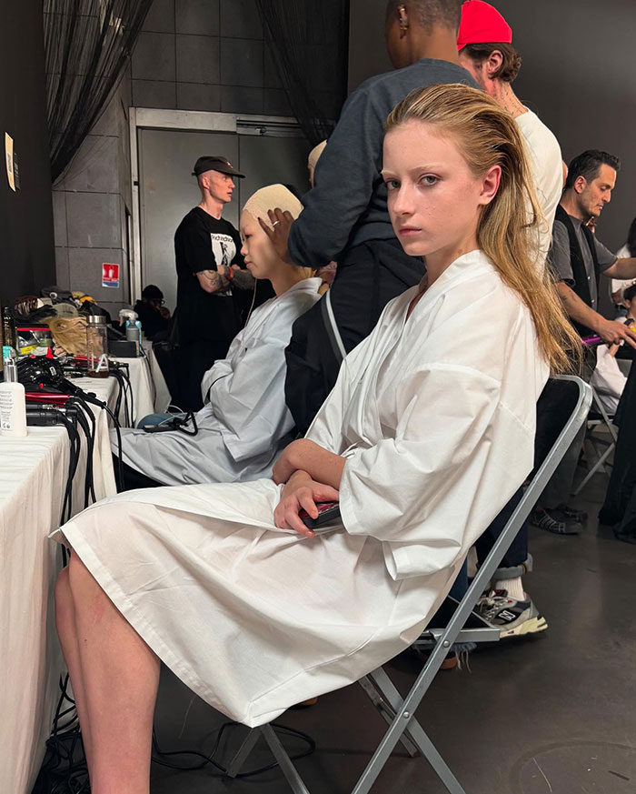 Young model in a white robe preparing backstage at Paris Fashion Week debut. Young model in a white robe preparing backstage at Paris Fashion Week debut.