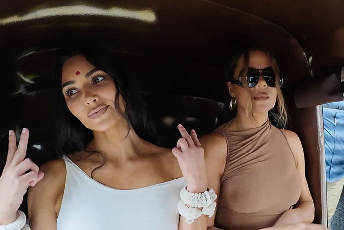 Two women in a vehicle, one with a bindi, posing and gesturing, reflecting modern cultural fashion. Two women in a vehicle, one with a bindi, posing and gesturing, reflecting modern cultural fashion.