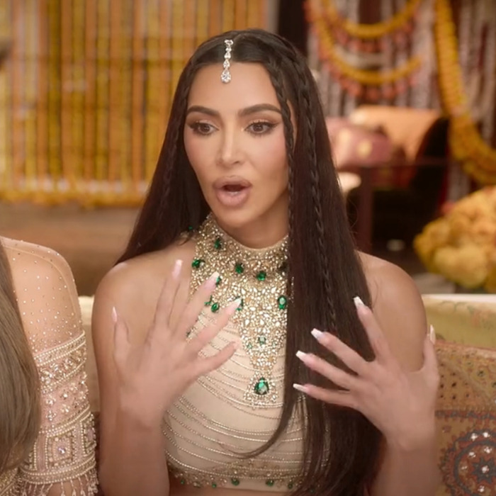 Woman expressing surprise, wearing a jeweled top and headpiece, hands raised with painted nails. Woman expressing surprise, wearing a jeweled top and headpiece, hands raised with painted nails.