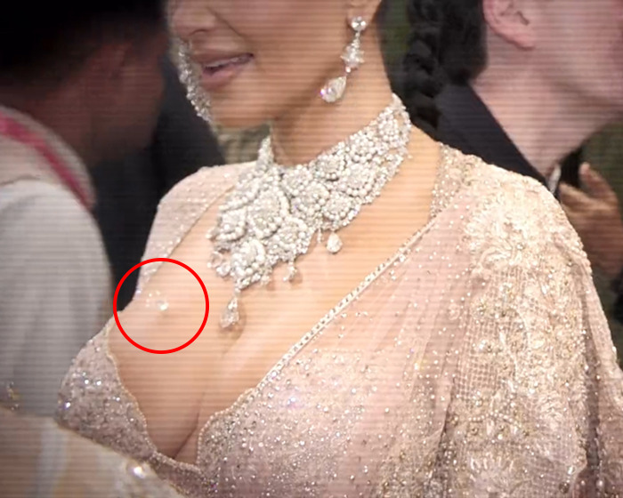 Woman in extravagant outfit, circled spot highlighting lost diamond, sparking publicity claims. Woman in extravagant outfit, circled spot highlighting lost diamond, sparking publicity claims.