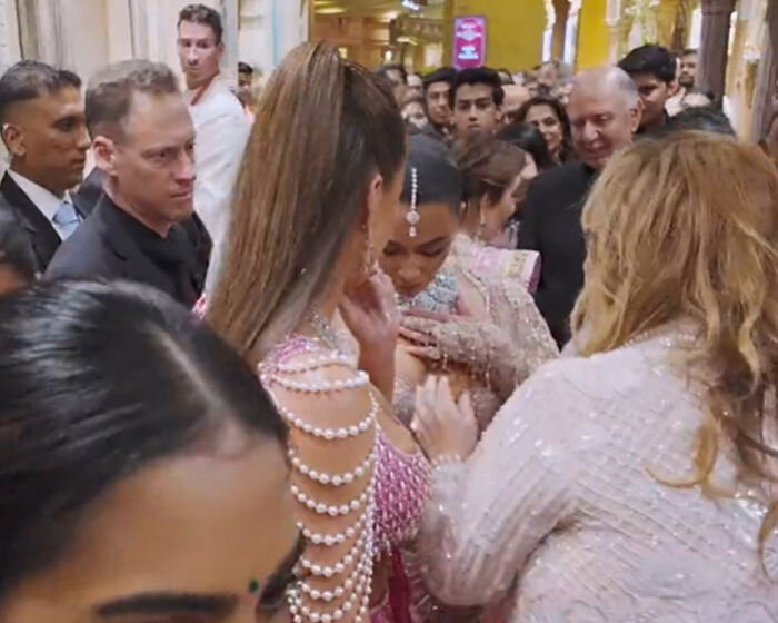 Group surrounding a woman in a crowded event, dressed in glamorous outfits, with a focus on discussion and attention. Group surrounding a woman in a crowded event, dressed in glamorous outfits, with a focus on discussion and attention.