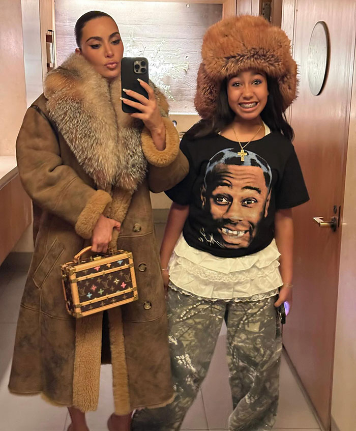Woman in fur coat takes mirror selfie with friend wearing a graphic tee, highlighting Dr. Phil's warning to Kim K. Woman in fur coat takes mirror selfie with friend wearing a graphic tee, highlighting Dr. Phil's warning to Kim K.