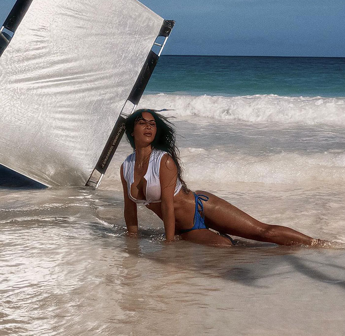 Bikini photo on beach with reflector screen in the background, sparking photoshop discussion. Bikini photo on beach with reflector screen in the background, sparking photoshop discussion.