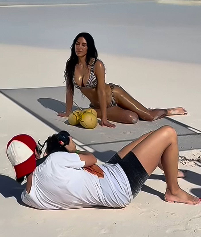 Photographer captures model in zebra bikini on beach during photoshoot. Photographer captures model in zebra bikini on beach during photoshoot.