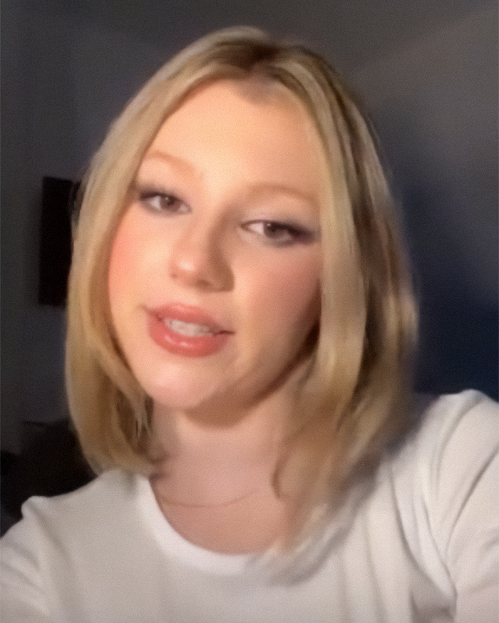 A woman discussing her experience about selling her virginity during college, wearing a white top. A woman discussing her experience about selling her virginity during college, wearing a white top.