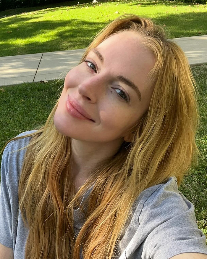 Lindsay Lohan smiling for a selfie outdoors. Lindsay Lohan smiling for a selfie outdoors.