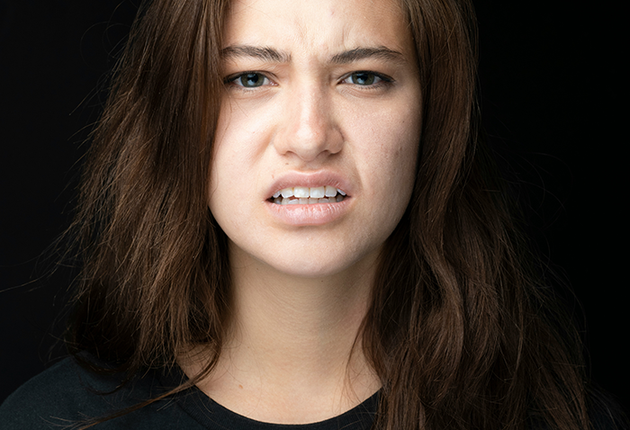 A woman expressing displeasure, symbolizing bridesmaid's reaction to a rude bride. A woman expressing displeasure, symbolizing bridesmaid's reaction to a rude bride.