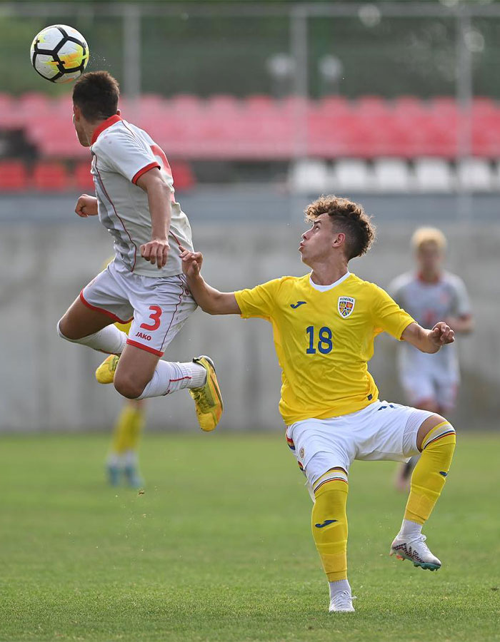 Two footballers compete intensely for the ball during a match. Two footballers compete intensely for the ball during a match.