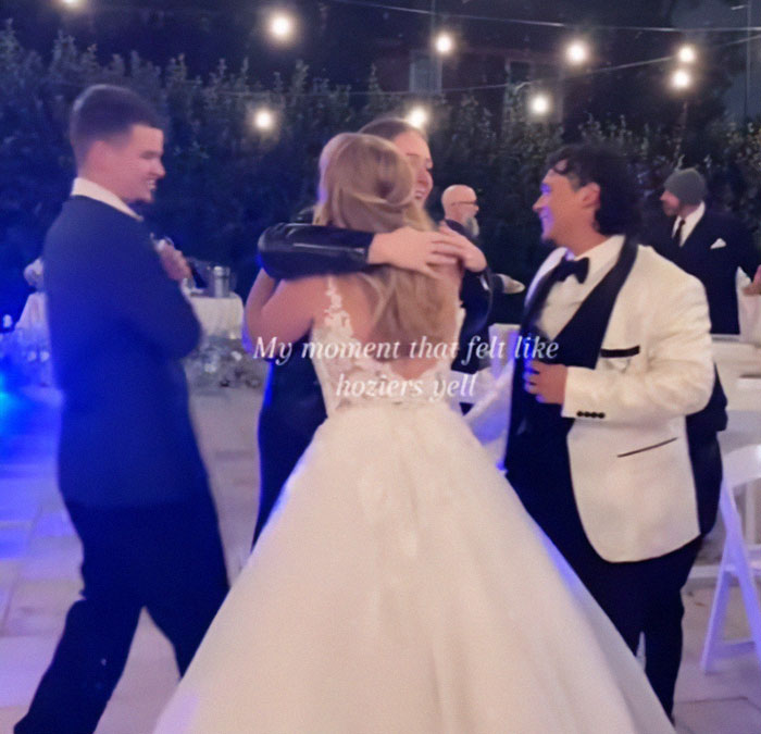 Couple embraces at wedding reception, capturing guests' surprise proposal reactions under string lights. Couple embraces at wedding reception, capturing guests' surprise proposal reactions under string lights.