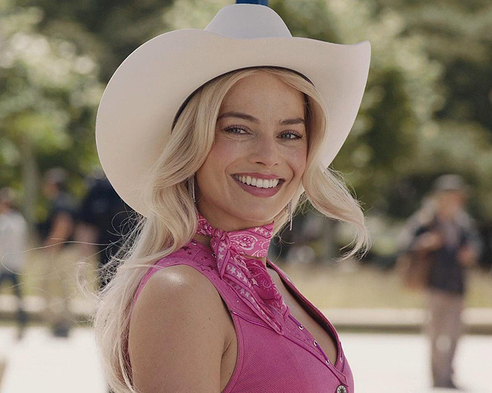 Blonde woman in a pink outfit with a white hat, outdoors, related to Wuthering Heights costume discussion. Blonde woman in a pink outfit with a white hat, outdoors, related to Wuthering Heights costume discussion.