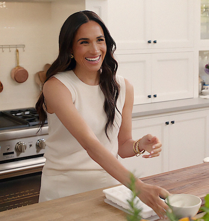 Smiling woman in a stylish kitchen, engaging in casual conversation. Smiling woman in a stylish kitchen, engaging in casual conversation.