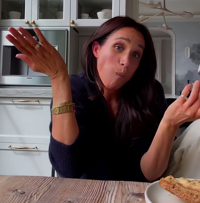 Woman in a kitchen, gesturing with raised hands, sparking Meghan Markle feud rumors discussion. Woman in a kitchen, gesturing with raised hands, sparking Meghan Markle feud rumors discussion.