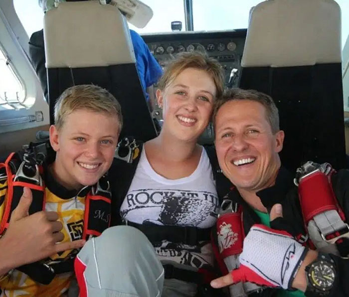 Family moment with Michael Schumacher, smiling in a plane, wearing parachute gear. Family moment with Michael Schumacher, smiling in a plane, wearing parachute gear.
