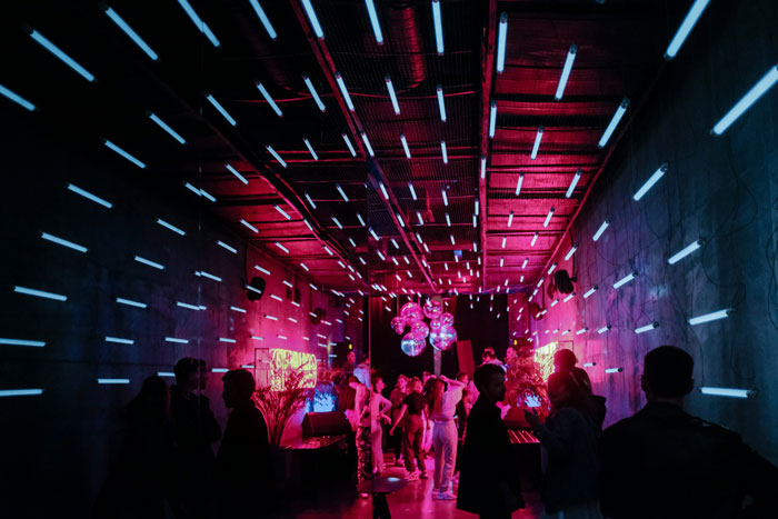 People socializing at a vibrant party with neon lights, linked to model's case and possible trafficking investigation activities. People socializing at a vibrant party with neon lights, linked to model's case and possible trafficking investigation activities.