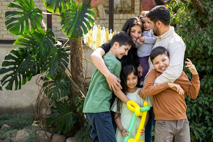 A family gathers outdoors with children holding a balloon, creating a warm, joyful atmosphere. A family gathers outdoors with children holding a balloon, creating a warm, joyful atmosphere.