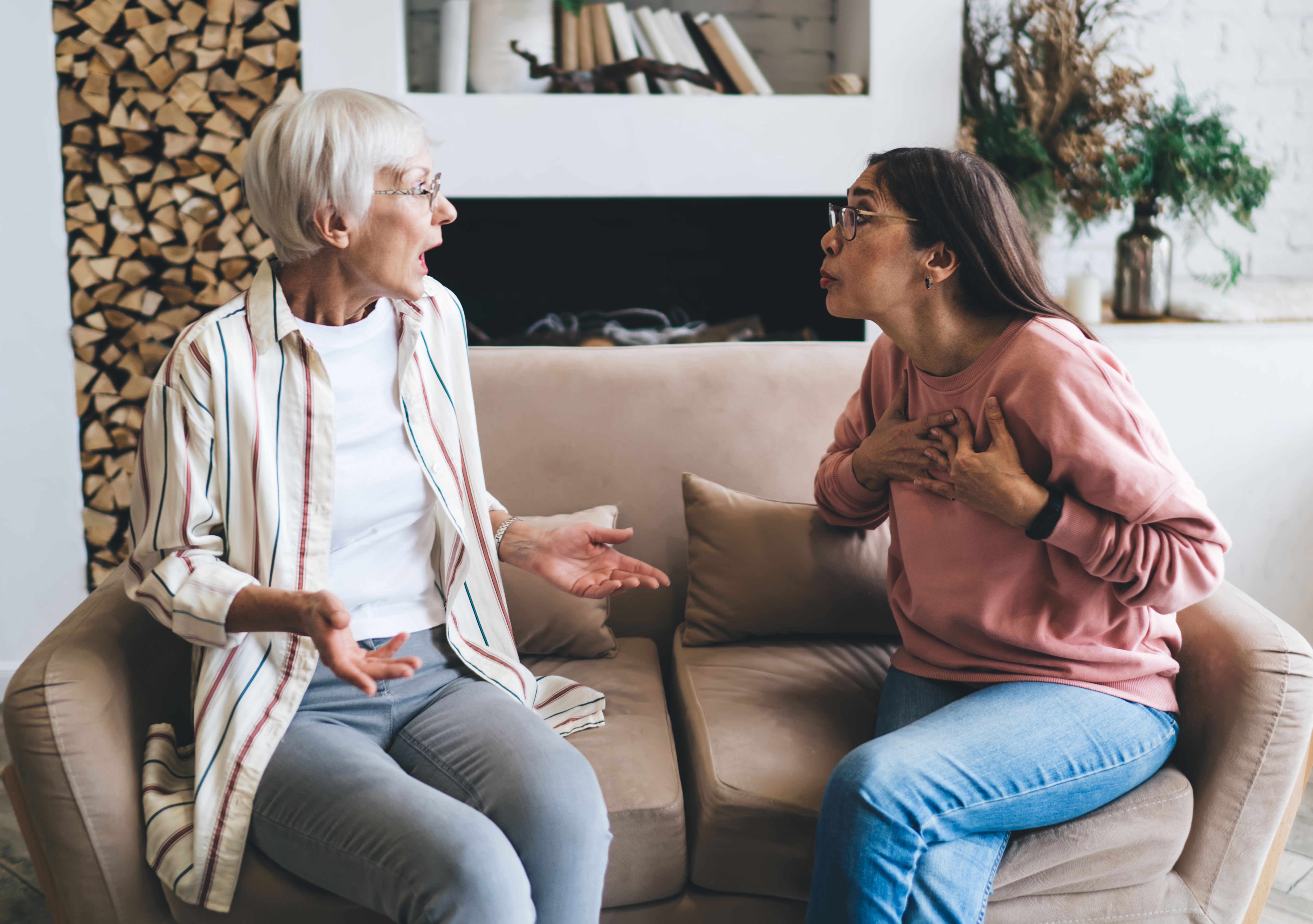 Two women having an intense conversation on a sofa, highlighting transformation and personal growth through living well. Two women having an intense conversation on a sofa, highlighting transformation and personal growth through living well.