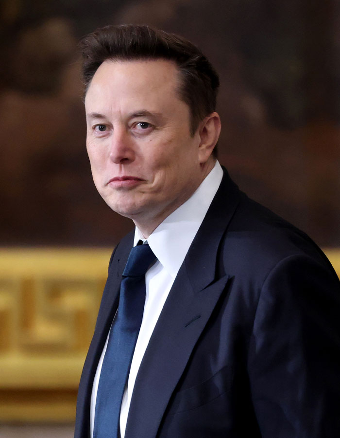 Man in a suit and tie, looking ahead, with a blurred background. Man in a suit and tie, looking ahead, with a blurred background.