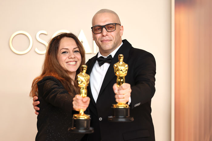 Two Oscar winners holding their trophies, smiling and wearing formal attire at the Oscars 2025. Two Oscar winners holding their trophies, smiling and wearing formal attire at the Oscars 2025.