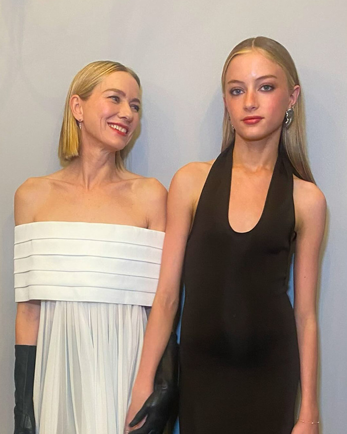 Naomi Watts and daughter pose on the red carpet, with daughter appearing indifferent. Naomi Watts and daughter pose on the red carpet, with daughter appearing indifferent.