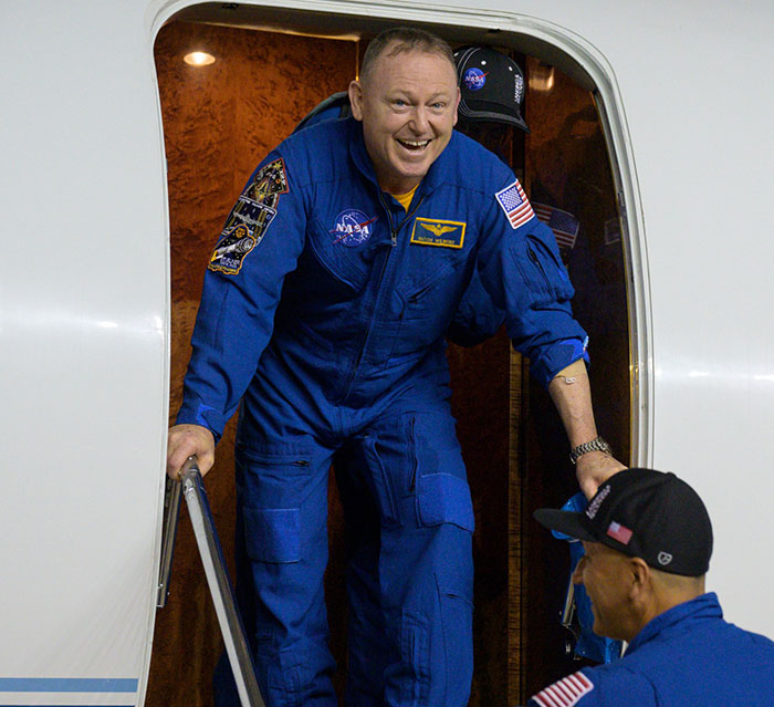 NASA astronaut exits spacecraft smiling, greeted by crew, concerns for his health arise post-Earth return. NASA astronaut exits spacecraft smiling, greeted by crew, concerns for his health arise post-Earth return.