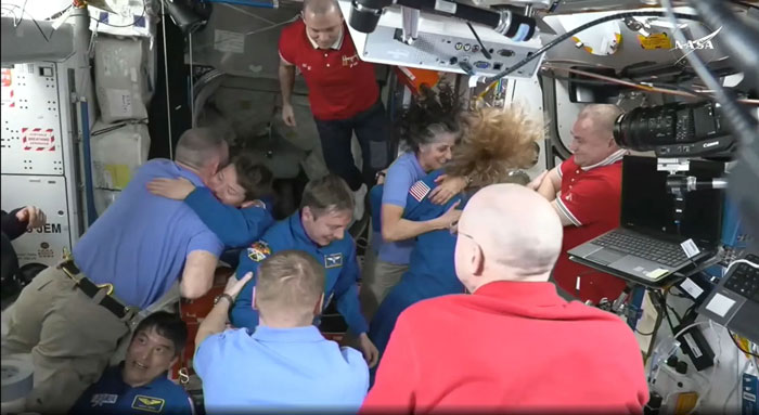 SpaceX crew arrives at ISS, astronauts celebrating and embracing in the space station module. SpaceX crew arrives at ISS, astronauts celebrating and embracing in the space station module.