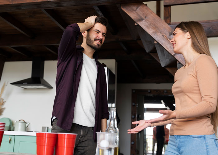 A couple arguing in a kitchen, red party cups on counter, echoing nightclub-like disturbance. A couple arguing in a kitchen, red party cups on counter, echoing nightclub-like disturbance.