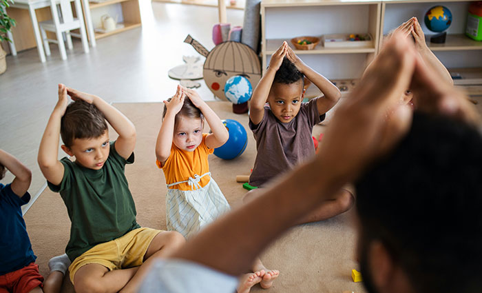 Children in a daycare setting participating in an interactive group activity led by a teacher. Children in a daycare setting participating in an interactive group activity led by a teacher.