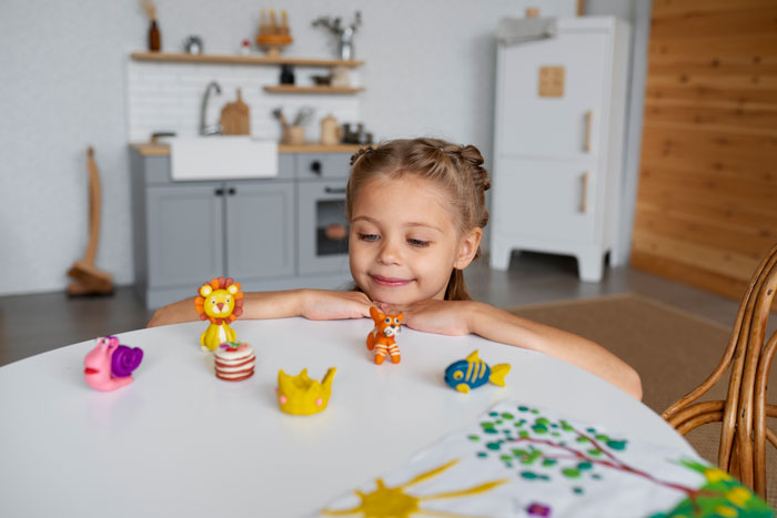 Young girl with toys at a table, representing aunt's response to sticky-fingers niece and stolen trinkets story. Young girl with toys at a table, representing aunt's response to sticky-fingers niece and stolen trinkets story.