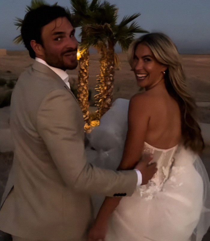 Bride and groom smiling during wedding photoshoot, palm trees in background. Bride and groom smiling during wedding photoshoot, palm trees in background.