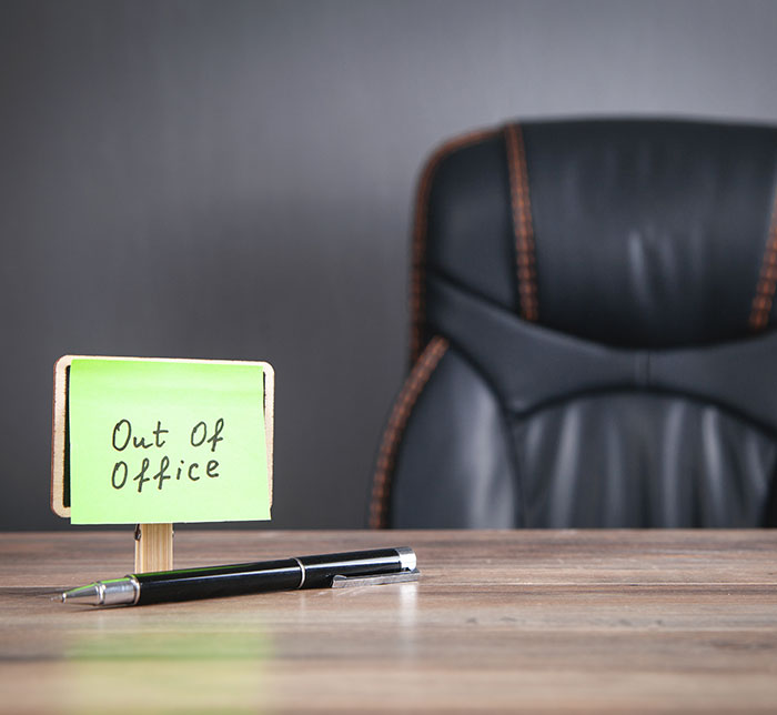 Out of office note beside a black chair, representing family-first vacation time. Out of office note beside a black chair, representing family-first vacation time.