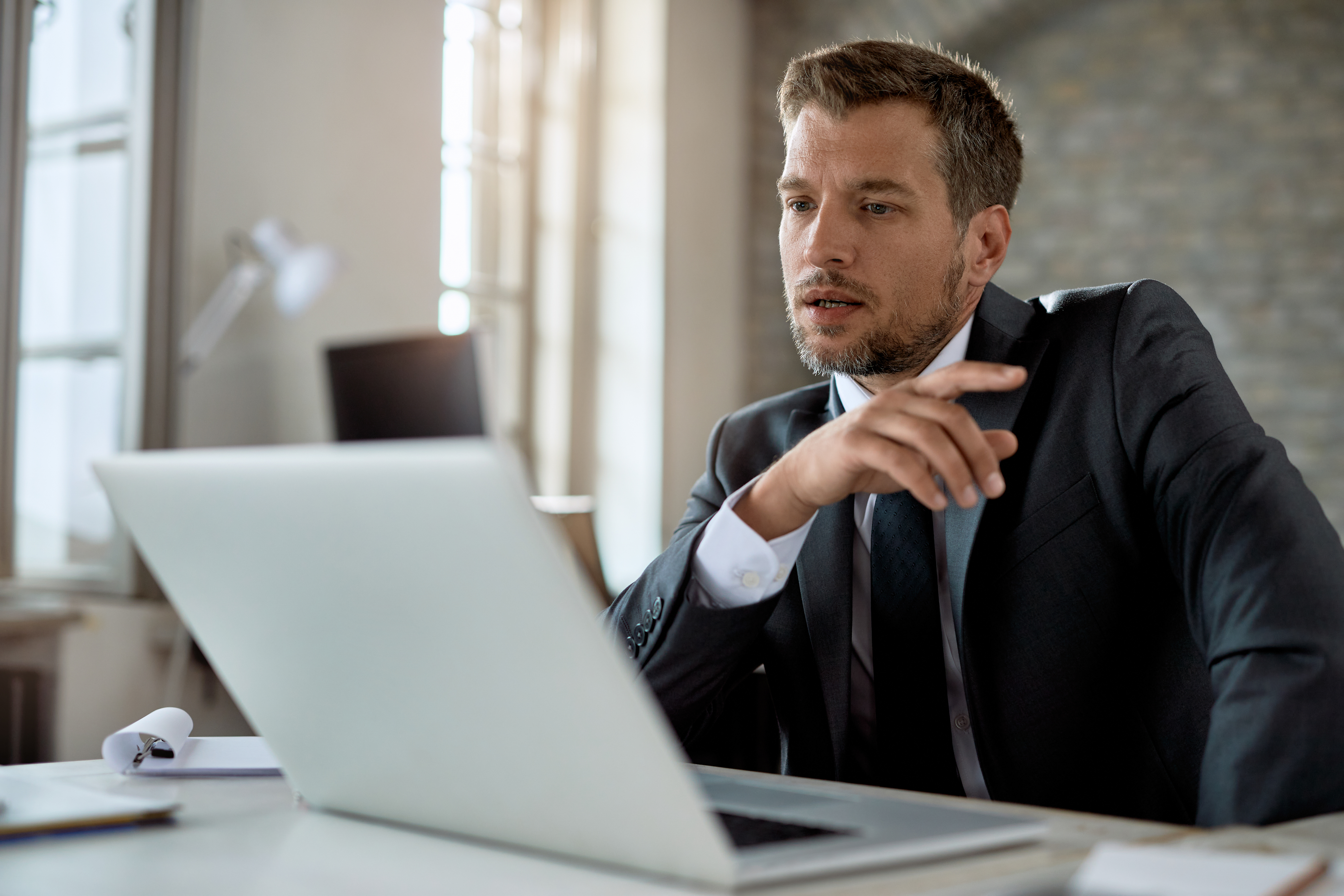 American boss in a suit, engaged in a video call at the office. American boss in a suit, engaged in a video call at the office.